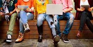 Jeunes gens assis avec des ordinateurs sur les genoux